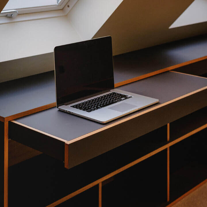 Bespoke minimalist pull-out desk within a custom built unit with open shelving. By Fundi Joinery in Scotland