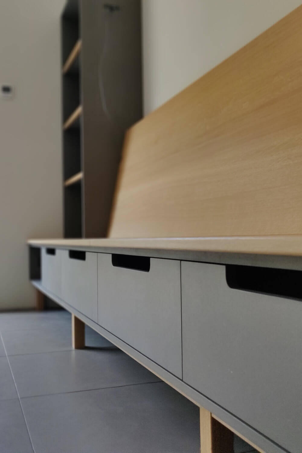 Bespoke minimalist oak and grey Valchromat bench seat with low level drawers sitting on solid oak legs by Fundi Joinery Edinburgh